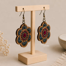 Cargar imagen en el visor de la galería, Crimson Roots embroidered wooden earrings shown at an angle to highlight their approximately 2.5 mm thickness.
