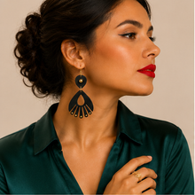 Cargar imagen en el visor de la galería, Model wearing Ebony Moon wooden earrings with an emerald satin blouse and red lipstick, showing the earrings at realistic scale.