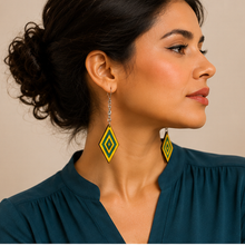 Cargar imagen en el visor de la galería, Model wearing Aurora Step wooden earrings with a deep petrol blue blouse, showing the yellow and green resin design at realistic scale.

