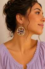 Cargar imagen en el visor de la galería, Model wearing Autumn Wings hand-painted wooden earrings with a soft lavender blouse and hair pulled back.

