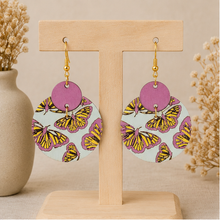 Cargar imagen en el visor de la galería, Boho Chic Butterfly wooden earrings displayed front-facing on a light wood stand.
