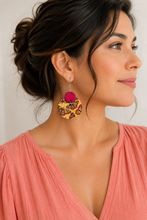 Cargar imagen en el visor de la galería, Model wearing hand-painted butterfly wooden earrings with a soft coral top, showing realistic scale.
