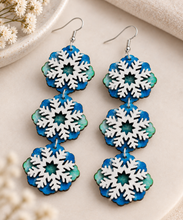 Cargar imagen en el visor de la galería, Close-up of Frozen Sky earrings showing three connected layered snowflake sections and hand-painted wood
