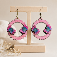 Cargar imagen en el visor de la galería, Mariposa Serena layered butterfly wooden earrings on a light wood stand
