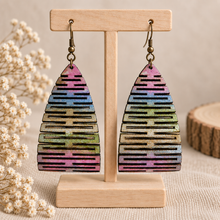 Cargar imagen en el visor de la galería, Pearlescent Rainbow hand-painted multicolor wooden earrings on a light wood stand

