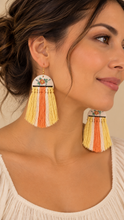 Cargar imagen en el visor de la galería, Model wearing Sun Whisper lightweight wooden earrings with hand-painted floral tops and long cream, yellow and coral macramé tassels
