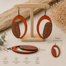 Cargar imagen en el visor de la galería, Tribal Feather lightweight wooden earrings on a light wood stand, showing 1.5 mm thickness and that the decorative design is on the front only.
